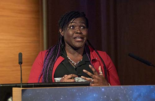 Maggie Arerin-Pocock speaking on stage